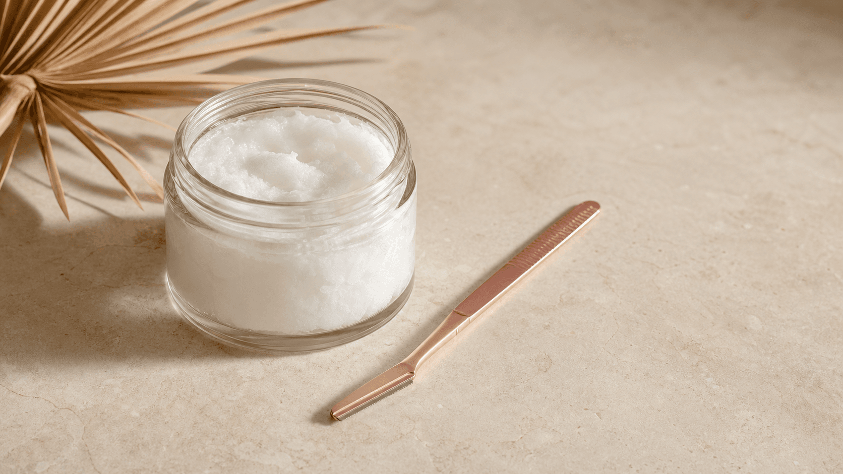 A jar of coconut oil beside a jasclair dermaplaning razor, a popular oil better skipped on the face